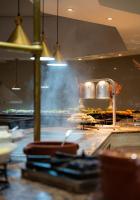 a kitchen with a grill with food on it at Hammamet Garden Resort and Spa in Hammamet