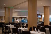 a dining room with tables and chairs with people in the background at Hammamet Garden Resort and Spa in Hammamet