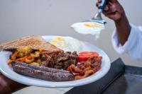 a plate of food with a hot dog and toast at Kang Juliet Hotel in Kang