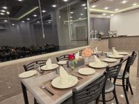 Una mesa larga con sillas y platos y flores sobre ella. en The charming view, en Wadi Musa