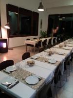 Un grupo de mesas largas con platos y sillas blancas. en Centro de Naturaleza Cañada Verde "El Bosque Encantado de Córdoba", en Hornachuelos