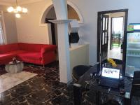 sala de estar con sofá rojo y mesa con ordenador portátil en MiniGolf, MeteoMode & B2B RESIDENCE Ekoumdoum - DAHARA APPARTS, en Yaoundé