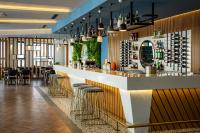 Un bar en un restaurante con mesas y sillas. en Helena Sea Breeze Apartments - Resort Living with Pools & Full Facilities, en Rizokarpaso