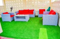 a living room with red and blue couches and grass at Ateker Hotel in Lodwar