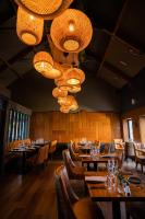 Un restaurante con mesas, sillas y lámparas de araña. en Cullinan's Guesthouse, en Doolin