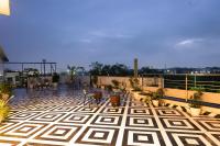 a patio with chairs and tables on a balcony at Aarchh Regency Noida in Noida