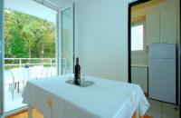 a kitchen with a white table with a bottle of wine on it at Apartman Tramontana in Opatija