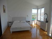a white bedroom with a bed and a large window at Apartman Tramontana in Opatija