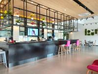 a bar in a restaurant with pink chairs and tables at 康铂酒店深圳国际会展中心店 in Shenzhen