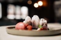 サースフェーにあるNavigare Resortsのテーブルの上にイチゴが入ったチョコレートデザートの皿