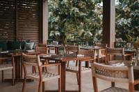 eine Reihe von Tischen und Stühlen in einem Restaurant in der Unterkunft Sanglung Villas & Suites in Kubutambahan