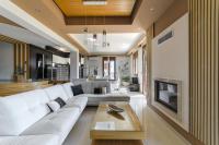 a living room with a white couch and a fireplace at Villa Under Meteora in Kalabaka
