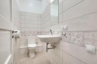 a white bathroom with a sink and a toilet at Orange Cat Rooms in Riga