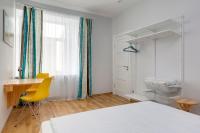 a bedroom with a desk and a table and yellow chairs at Orange Cat Rooms in Riga