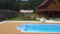a swimming pool in front of a house and a building at Guest House in Carpathians in Migovo
