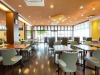 a restaurant with tables and chairs and windows at Rembrandt Inn Kazusa in Kimitsu