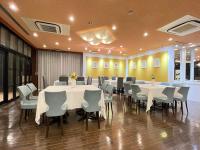 a dining room with white tables and chairs at Rembrandt Inn Kazusa in Kimitsu