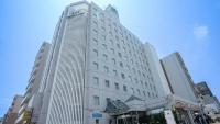 a tall white building on a city street at Hotel Casabella Inn Kobe in Kobe