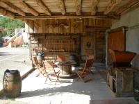 a patio with chairs and a table and a stove at Le Clos Fleuri in Caumont