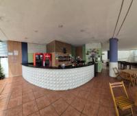 een bar in een restaurant met een toonbank en stoelen bij Apartamento a beira mar in Natal