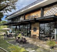 Un restaurante con mesas y sillas delante. en Sitio Uno Residences - Pueblo de Panay - F&M Homes, en Roxas City