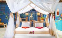 una cama en una habitación con una pared azul en Kaya Kwetu, en Msambweni