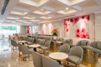 um restaurante com mesas e cadeiras e uma grande pintura na parede em Le Saigon Grand Hotel em Cidade de Ho Chi Minh