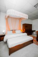 1 dormitorio con 1 cama grande con dosel de naranja en Mbeya Forest Hill Motel, en Mbeya