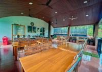 um quarto amplo com mesas e cadeiras de madeira em Kedara Resort Wayanad by VOYE HOMES - Pet Friendly with Pool em Sultan Bathery