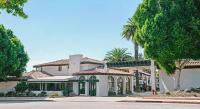 Una gran casa blanca con palmeras y una calle. en Sands Inn &amp; Suites, en San Luis Obispo