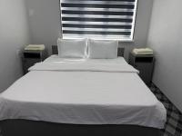 1 cama blanca grande con 2 almohadas y ventana en SILVER HOTEL navoiy, en Navoi