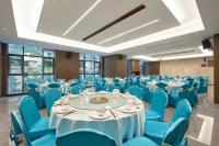 景洪にある西双版纳熙源国际酒店のテーブルと青い椅子が備わる宴会場