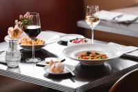 una mesa con platos de comida y copas de vino en Mövenpick Hotel Amsterdam City Centre, en Ámsterdam