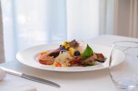 Un plato de comida en una mesa con un vaso. en Excelsior Palace Hotel, en Taormina