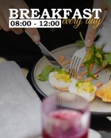 EjmiatsinSim Plaza Hotel的一个人用刀叉在盘子里切鸡蛋。