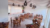 Cupe Beach Living Resort By Flatbpaiva في بورتو دي غالينهاس: مطعم بطاولات وكراسي خشبية في الغرفة