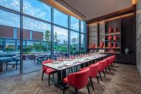 a dining room with a long table and red chairs at Crowne Plaza Beijing Tongzhou in Beijing
