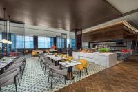 a restaurant with tables and chairs and a kitchen at Crowne Plaza Beijing Tongzhou in Beijing
