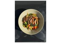 a bowl of food with meat and vegetables in it at Nautilus Beach Resort by Charlesworth in Coffs Harbour