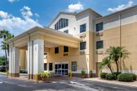 Un gran edificio con palmeras delante. en Comfort Inn &amp; Suites DeLand - near University, en De Land