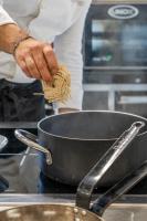 una persona sosteniendo un montón de fideos en una olla en Hub Hotel, en Gubbio