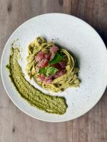 a plate of pasta with meat and greens on a table at BAIA - Beachfront Boutique Lodge in San Vicente, Palawan in San Vicente