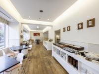 una cocina con encimeras blancas, mesa y sillas en KOKO HOTEL Yokohama Tsurumi, en Yokohama