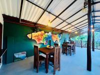 坦加拉Ceylan Breeze Beach Resort的餐厅里有一张桌子和几把椅子