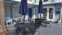 2 Tische und Stühle mit Sonnenschirmen auf einer Terrasse in der Unterkunft Edgewater Inn in Myrtle Beach