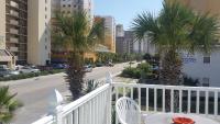 einen Balkon mit einem Tisch, Stühlen und Palmen in der Unterkunft Edgewater Inn in Myrtle Beach
