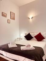 Un dormitorio con una gran cama blanca con almohadas rojas. en Alojamento Local Tamega, en Amarante