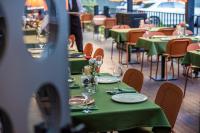 Una mesa con mesas y sillas verdes en un restaurante. en Hotel Twenties Tbilisi - Stay & Dine, en Tiflis