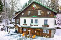 a large wooden house with snow on the ground at Penzion Sofinata &amp; Pizzeria Špindlerův Mlýn in Špindlerův Mlýn