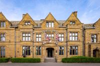 Un gran edificio de ladrillo con dos banderas británicas en el frente. en Whately Hall Hotel, en Banbury